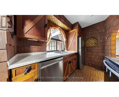 A kitchen with wooden cabinets and a brick wall.