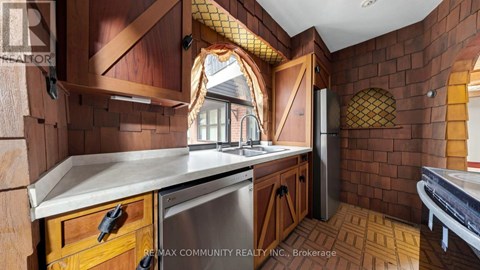 A kitchen with wooden cabinets and a brick wall.