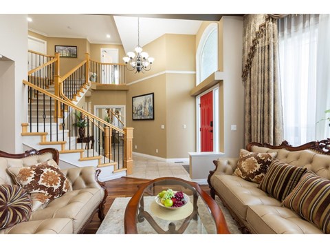 A living room with a brown couch and a glass coffee table.