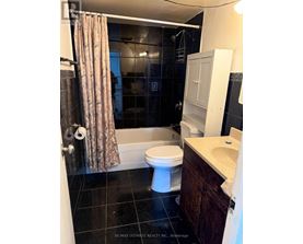 A bathroom with a toilet, sink, and shower.