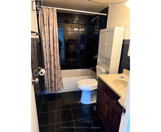 A bathroom with a toilet, sink, and shower.