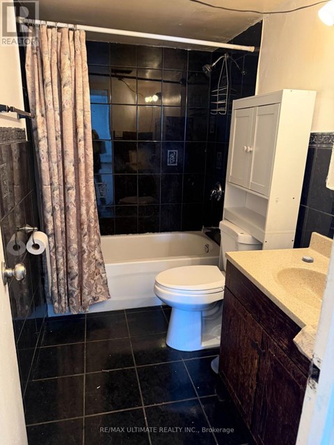 A bathroom with a toilet, sink, and shower.