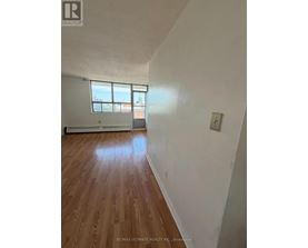 A room with a window and a wooden floor.