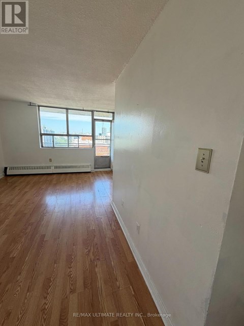 A room with a window and a wooden floor.
