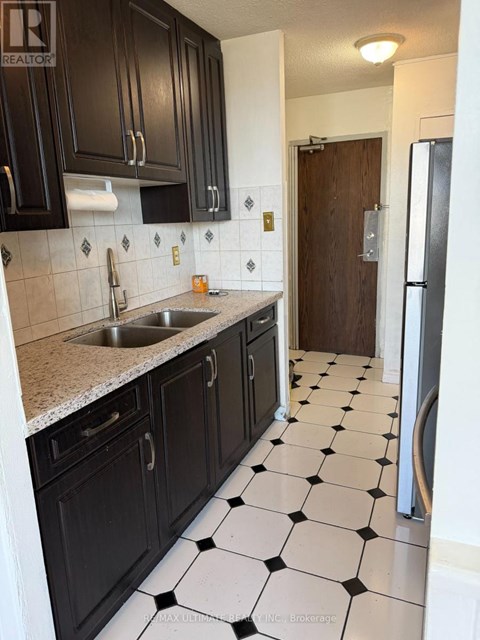 A kitchen with black cabinets and a checkered floor.