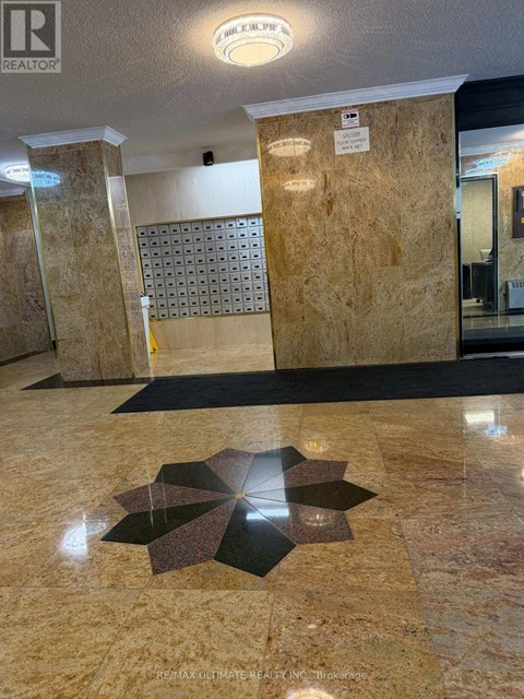 A hallway with a tile floor and a tile wall with a pattern.