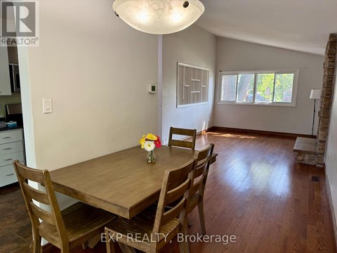 A dining room with a wooden table and chairs.