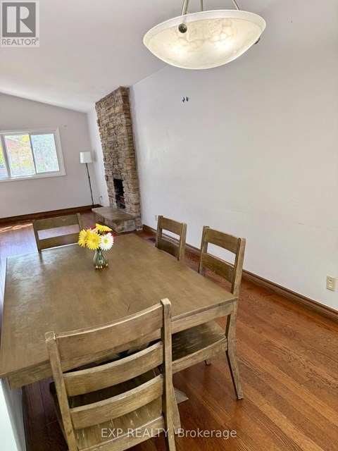 A dining room with a wooden table and chairs.
