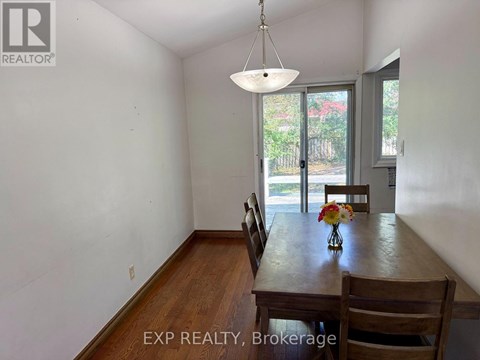 A dining room with a wooden table and chairs.