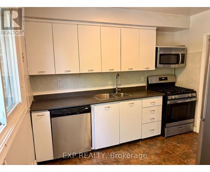 A kitchen with white cabinets and a black counter top.