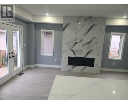 A marble fireplace in a room with grey walls and a window.