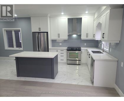 A modern kitchen with white cabinets and a marble countertop.