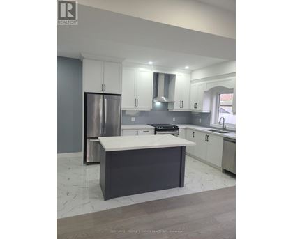 A modern kitchen with a large island and stainless steel appliances.