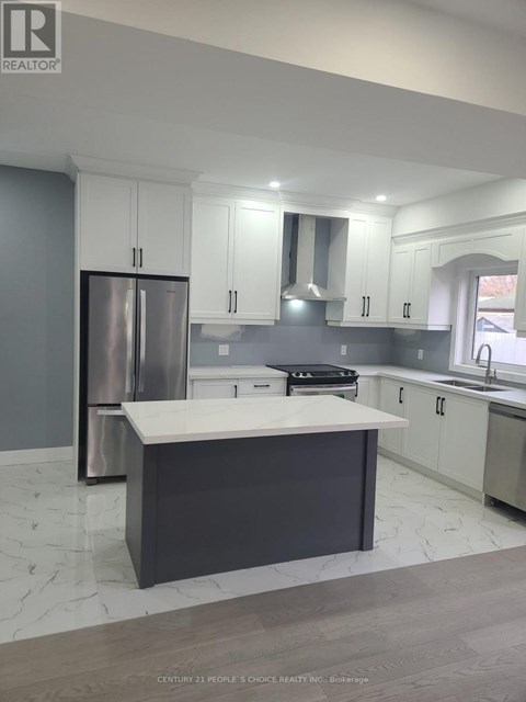 A modern kitchen with a large island and stainless steel appliances.