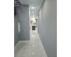 A long hallway with marble floors and white walls.