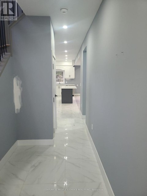 A long hallway with marble floors and white walls.