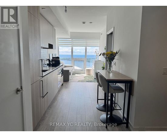 A kitchen with a bar stool and a view of the water.