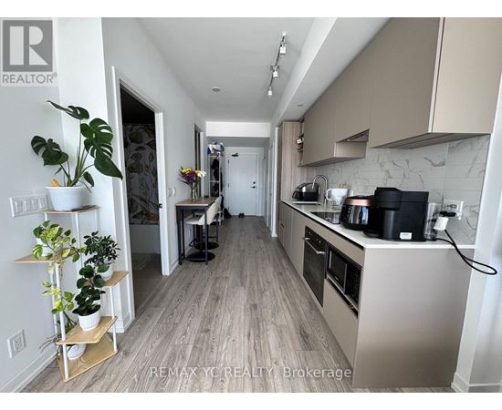 A kitchen with a white counter top and a plant on it.