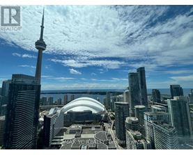 A cityscape with tall buildings and a tall tower in the background.