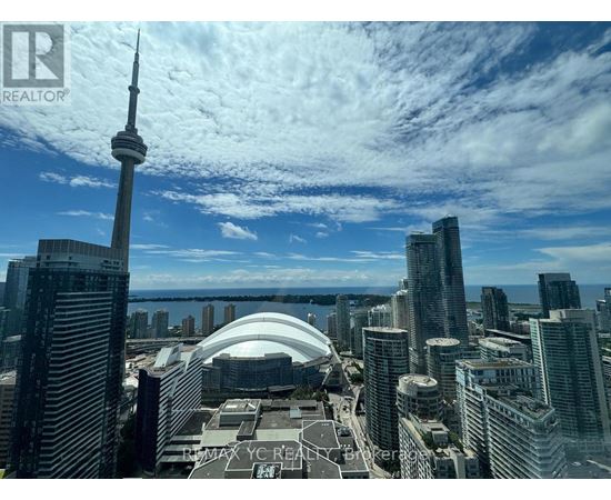 A cityscape with tall buildings and a tall tower in the background.