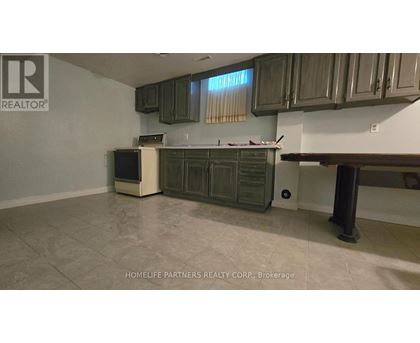 A kitchen with a refrigerator, oven, and cabinets.