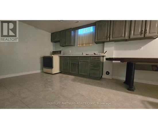 A kitchen with a refrigerator, oven, and cabinets.