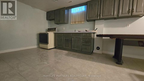 A kitchen with a refrigerator, oven, and cabinets.
