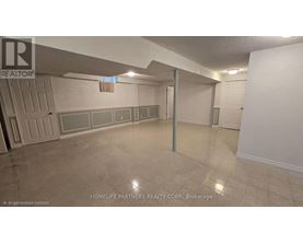 A room with a white wall and a grey floor.