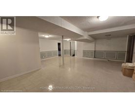 A spacious room with a tiled floor and white walls, with a door in the middle of the room.