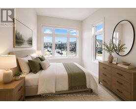 A bedroom with a large bed, a nightstand with a lamp, and a round mirror on the wall.