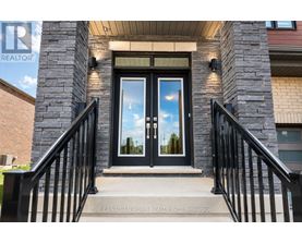The entrance to a building with a glass door and a sign that reads "The Canadian Home Realty Inc. Brokerage."