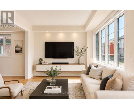 A living room with a white couch and a flat screen TV mounted on the wall.