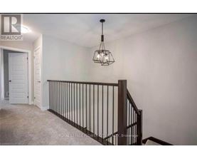 A room with a chandelier and a staircase.