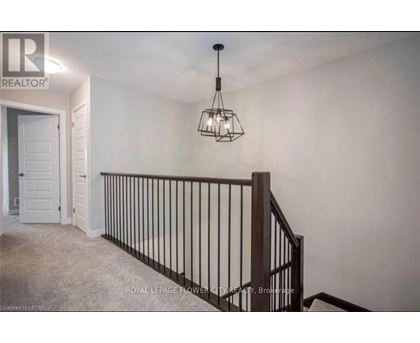 A room with a chandelier and a staircase.