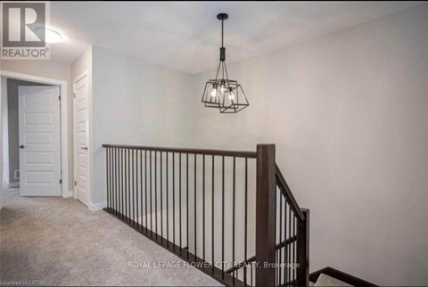 A room with a chandelier and a staircase.