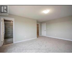 A spacious room with a door on the left and a carpeted floor.