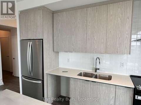 A kitchen with a sink and a refrigerator.