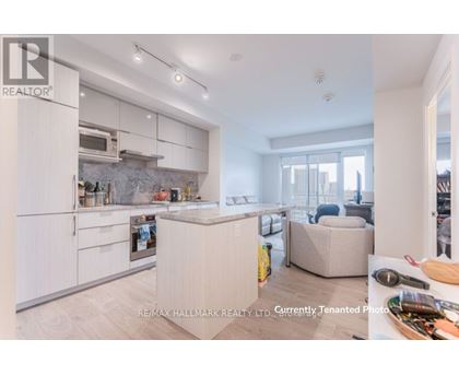 A modern kitchen with white cabinets and a marble backsplash.