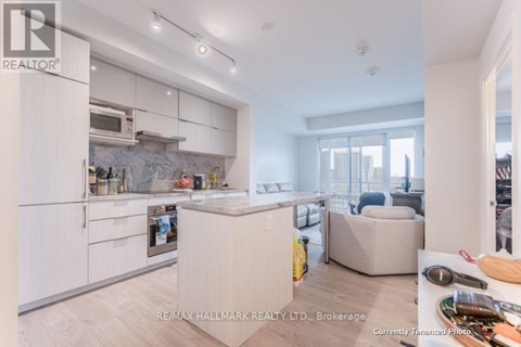 A modern kitchen with white cabinets and a marble backsplash.