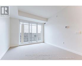 A white room with a window showing a view of a building.