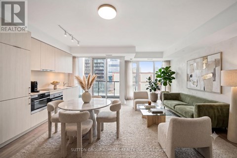 A well-lit, modern kitchen and living room with a dining table and chairs.