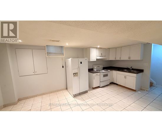 A kitchen with white appliances and cabinets.