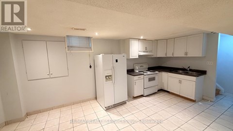 A kitchen with white appliances and cabinets.