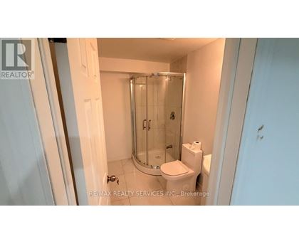 A small white bathroom with a toilet, a sink and a shower.