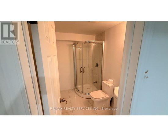 A small white bathroom with a toilet, a sink and a shower.