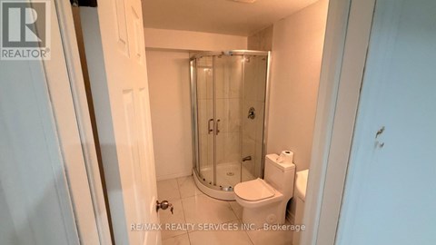 A small white bathroom with a toilet, a sink and a shower.