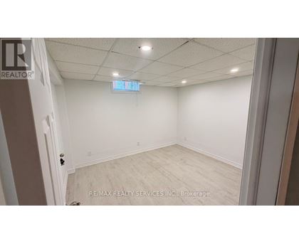 A room with white walls and a wooden floor is shown.