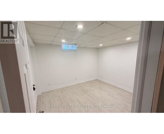A room with white walls and a wooden floor is shown.