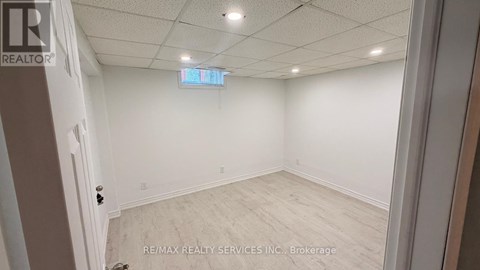 A room with white walls and a wooden floor is shown.