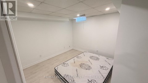 A bedroom with a bed in the middle and a sign on the wall.
